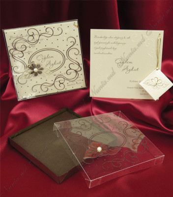 <p>Invitație de nuntă confecționată dintr-un carton bej destinat tipăririi textului, care se introduce într-o cutie de carton, acoperită de un plastic transparent cu model floral reliefat și o perlă.</p>