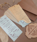 <p>Invitație de nuntă confecționată dintr-un carton lucios destinat textului. Peste cartonaș cu ajutorul unei sfoare aurii se suprapune o foaie transparentă cu imprimeu auriu. În costul invitației este inclus un plic bej sidefat.</p>
