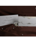 <p>Invitație de nuntă clasică, confecționată dintr-un carton alb cu elemente aurii reliefate destinat imprimării textului. Acesta este introdus într-un plic ce se pliază în două pe orizontală și care păstrează același design ca și al invitației.</p>