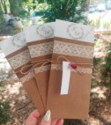 <p>Invitație de nuntă realizată din carton crem destinat imprimării textului. Invitația este introdusă într-un carton de tip buzunar, ornamentat cu elemente de tip dantelă și accesorizat cu o fundiță din sfoară de cînepă, de care atîrnă o etichetă prinsă cu un trandafir roșu. În calitate de plic servește o folie transparentă cu adeziv dublu.</p>