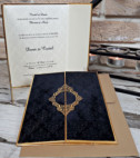 <p>Invitație elegantă, confecționată dintr-un carton gros de culoare neagră catifelat cu ornament și margini aurii, care se pliază în trei pe orizontal, în care găsim textul imprimat pe un carton crem cu ornamente pe fundal. În interior, marginele invitației tot sunt aurii. Invitația conține plic maro sidefat.</p>
