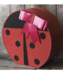 Cutie de dar realizată în formă de buburuză de culoare roșie și negru, folosită pentru plicurile oferite de invitați la botez, accesorizată cu fundiță roz. Aceasta reprezintă un accesoriu elegant și util în același timp.