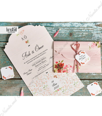 <p>Invitație de nuntă în nuanțe pastelate cu imprimeu floral și lemn care se pliază în trei pe orizontală. În interior pe partea din mijloc se printează textul iar la suprapunerea copertelor formează un cufăr accesorizat cu o panglică roz și o etichetă.</p>