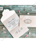 <p>Invitație de nuntă elegantă formată dintr-un carton pliat în trei pe orizontală de culoare roz pudrat. Textul se printează în partea de mijloc și se închide datorită decupajului pe partea de sus a invitației în formă de chenar cu imprimeu clasic unde se printează inițialele mirilor.</p>