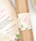 <p>Invitație de nuntă confecţionată dintr-un carton de culoare maronie cu ţinutele mirilor şi diverse imprimeuri florale. Textul este imprimat pe un carton separat, care se rulează și se introduce într-un tub hexagonal. Tubul are ca accesoriu o bandă cu iniţialele mirilor.&nbsp;</p>